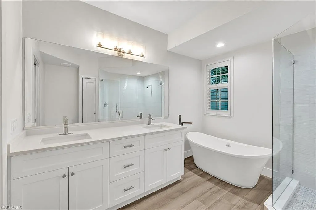 Bathroom with a double vanity, freestanding bath and glass shower